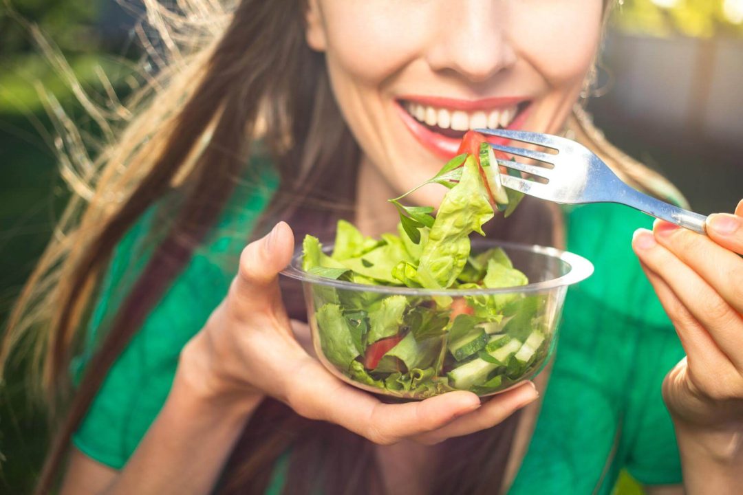 野菜を頬張る女性