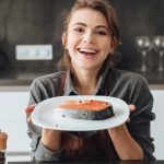 笑顔でフレッシュな魚をもつを女性